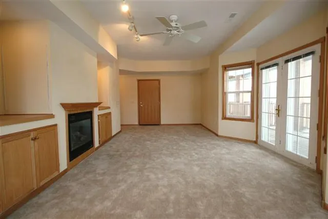 Lower-level living room with gas fireplace and built-in bookshelves